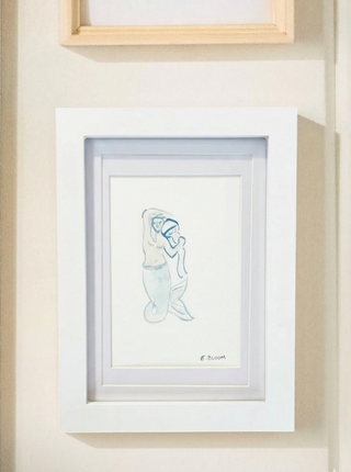 Framed artwork of a mermaid on a wall