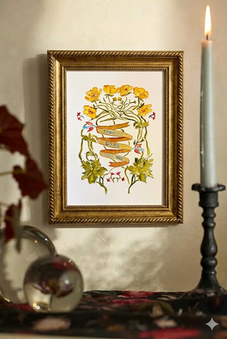 Framed artwork with floral design on a wall next to a candle