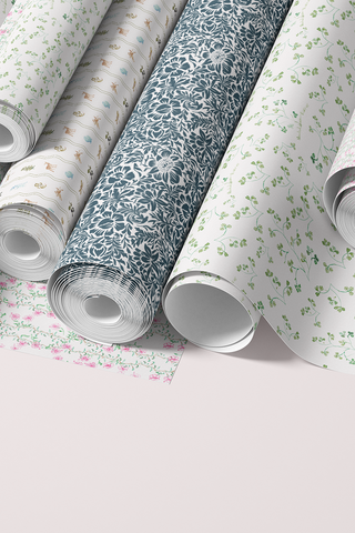Rolls of floral-patterned paper on a light pink background