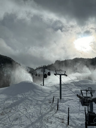 Ski lift in a snowy mountain landscape with a cloudy sky