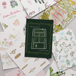 Collection of various greeting cards with different designs on a gray surface