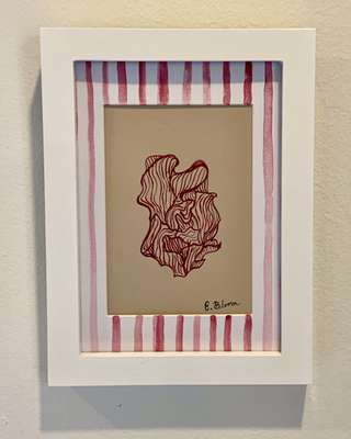 Framed artwork with a red abstract design on beige paper, set against a striped red and white background.
